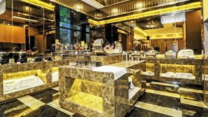 Un hall d’hôtel luxueux, avec un sol en marbre, des coins salons confortables et un comptoir d’accueil central.