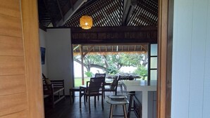 Un espace intérieur à aire ouverte comprenant un coin repas, une cuisine et une vue sur l’extérieur.