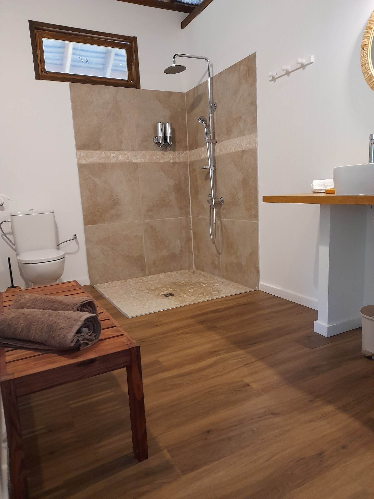 Een moderne badkamer met douche, toilet en wastafel.