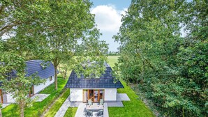 A modern house with a patio and a view of a green field. - Wieringen Waddenlodge (Den Oever)