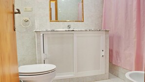 A bathroom with a toilet, a sink, and a bathtub. - Apartment Violeta on the second floor (Conil de la Frontera)