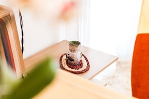 A small table with a decorative vase on a woven coaster.