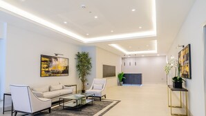 Ein modernes Wohnzimmer mit einer Couch, Sesseln, einem Couchtisch und einem Kamin.