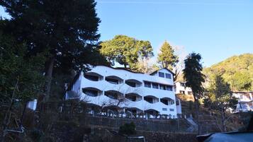 Un edificio de varios pisos con un diseño arquitectónico único, que presenta ventanas en arco y balcones.