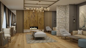 A modern living room with a fireplace, comfortable seating, and a stone accent wall. - Sarovar Portico Srinagar (Budgam)