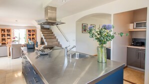 A modern kitchen with a stainless steel island, a built-in microwave, and a staircase leading to an upper level. - Villa within walking distance of Flayosc (Flayosc)