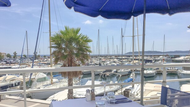 A table set for dining with a view of a marina filled with boats. - Villa within walking distance of Flayosc (Flayosc)