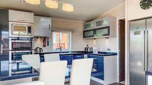 A modern kitchen with a central island, built-in appliances, and a large refrigerator.