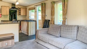 A compact living space with a kitchenette, a sofa, and a dining area.