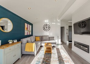 Una sala de estar moderna con sofá, mesa de centro y televisor.