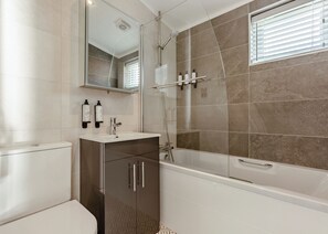 A modern bathroom with a shower, toilet, and sink. - Luxurious lodge with vaulted ceilings and a welcoming feature fireplace. (Glastonbury)