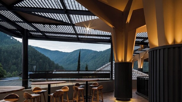 En restaurang med utsikt över bergen, möbler i trä och en modern inredning.