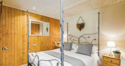 Stylish open plan lodge with king-size four poster bed.