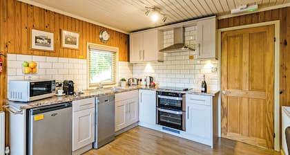 Stylish open plan lodge with king-size four poster bed.