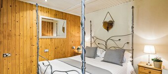 Stylish open plan lodge with king-size four poster bed.