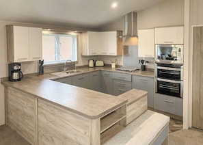 Una cucina moderna con isola centrale, elettrodomestici in acciaio inossidabile e mobili in legno chiaro.