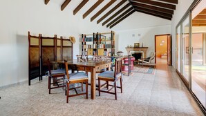 Un comedor con una mesa y sillas de madera, una estantería y una chimenea.
