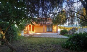 Una casa con patio, un jardín pequeño y vistas del paisaje circundante.