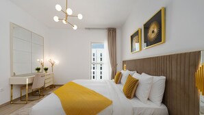 Quarto de hotel moderno com uma cama grande, uma escrivaninha e um espelho.