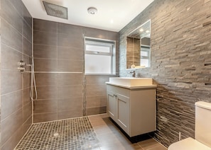 A modern bathroom with a shower, a sink, and a toilet. - Luxuriously modern and spacious two storey cottage. (Glastonbury)