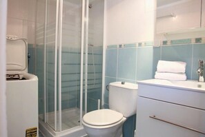 Une salle de bain avec une douche à parois de verre, des toilettes et un lavabo avec un miroir au-dessus.