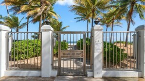 Ein verschlossenes Tor mit einem Schild mit der Aufschrift 'Verda del Mar', das zu einem Strand führt.