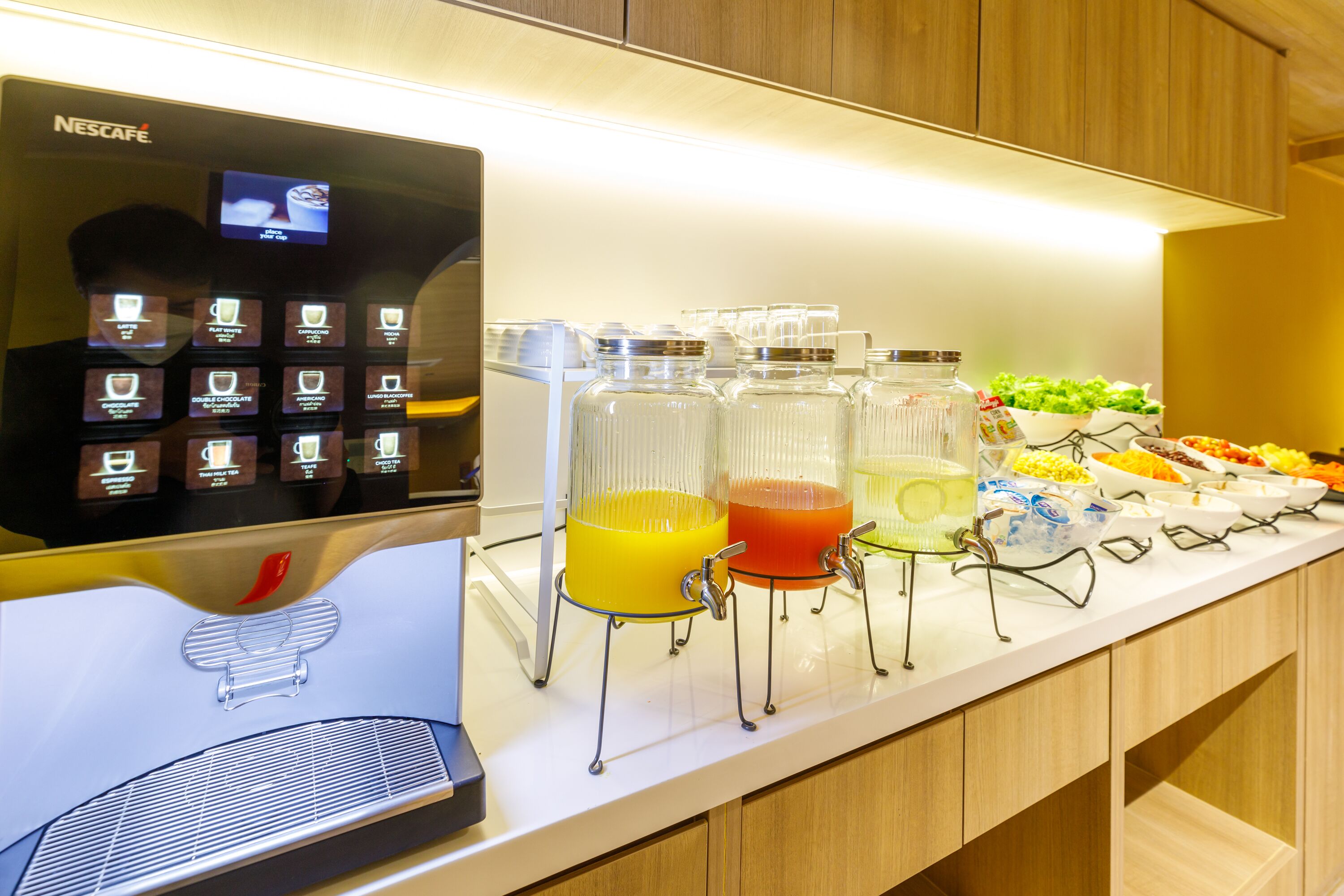 A buffet area with a Nescafe coffee machine and various food and drink dispensers.
