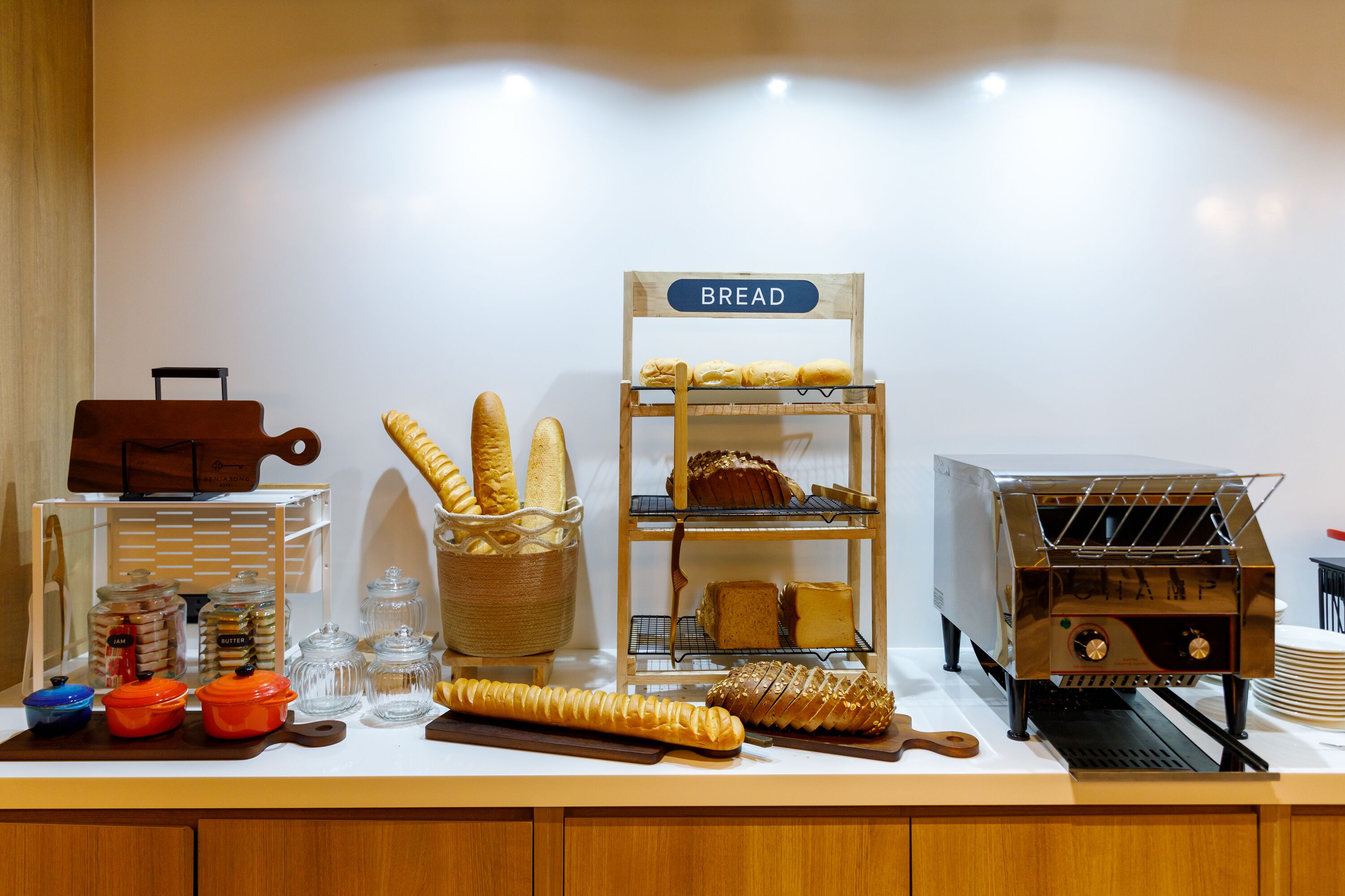A breakfast buffet with various breads, pastries, and a coffee machine.