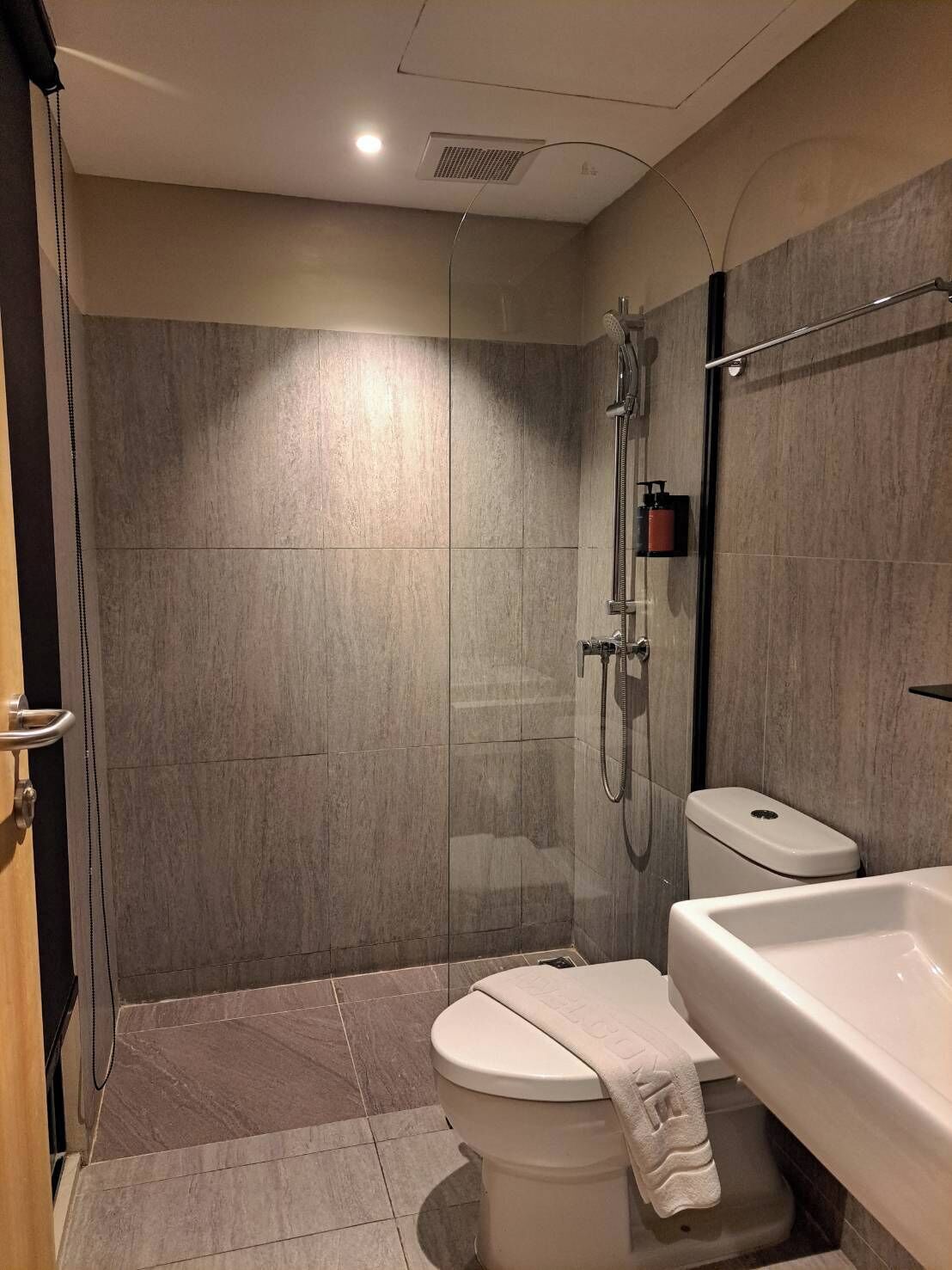 A modern bathroom with a glass-enclosed shower, a toilet, and a bathtub.