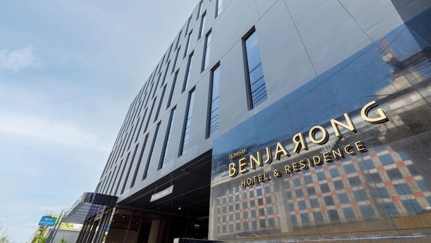 Um edifício moderno com fachada de vidro refletante e o nome "BENJARDO" em destaque.
