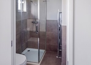 A glass-enclosed shower stall with a handheld showerhead, a wall-mounted faucet, and a step into the shower. - 3 bedroom accommodation in Newbury (Newbury)