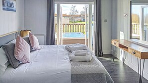 A bedroom with a bed, a desk, and a view of a backyard. - 3 bedroom accommodation in Newbury (Newbury)