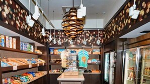 A store interior with wooden flooring, shelves stocked with snacks, a central display, and hanging lights. - 3 Bedroom 2 Bath Condo Disney area 8601 (Orlando)