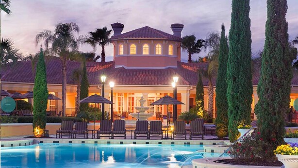 A hotel with a swimming pool, lounge chairs, and a fountain. - 3 Bedroom 2 Bath Condo Disney area 8601 (Orlando)