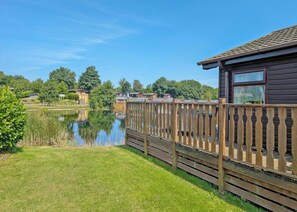 A lakeside property with a wooden deck and a view of the lake. - 3 bedroom accommodation in Carnforth (Carnforth)