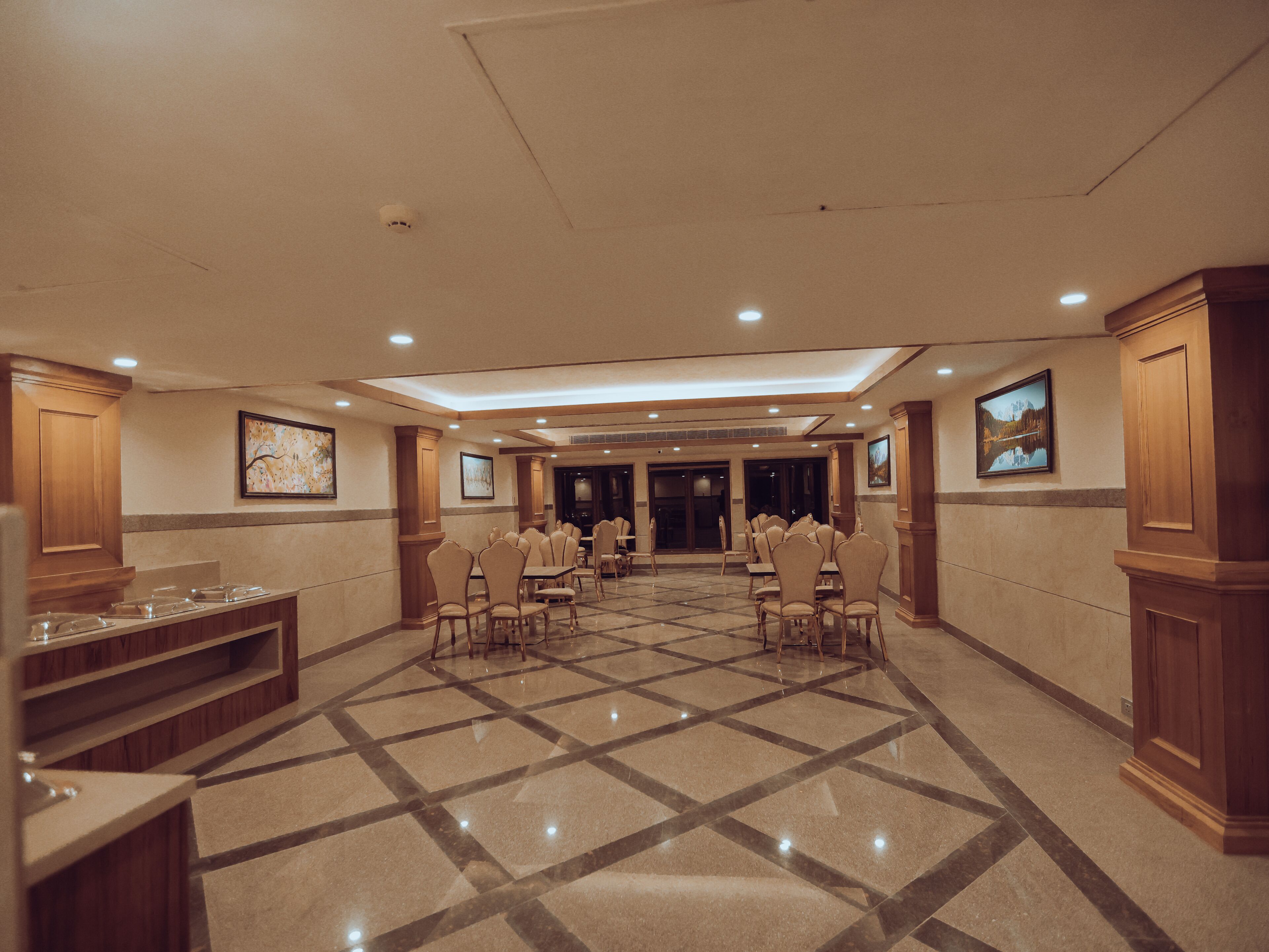 A spacious conference room with a tiled floor, multiple tables, and chairs arranged for meetings.