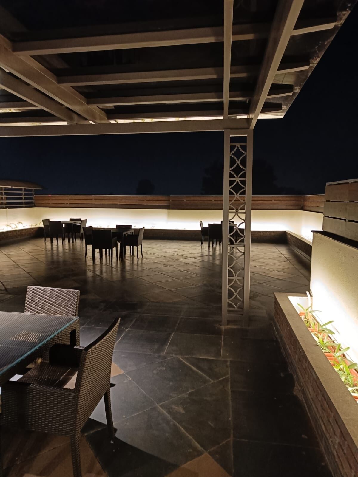 An outdoor patio area with a covered seating arrangement and a fire pit.