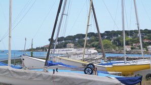 A marina with several boats docked, a clear sky, and a coastal town in the background. - Contemporary Apartment in Antibes with Terrace (Antibes)