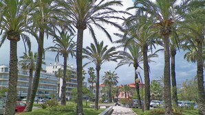 A paved walkway lined with palm trees and buildings in the background. - Contemporary Apartment in Antibes with Terrace (Antibes)