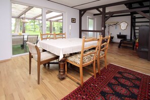 Enjoy meals in this cozy dining area with a table for four, comfortable chairs, and a large window offering a view of the outdoors.
