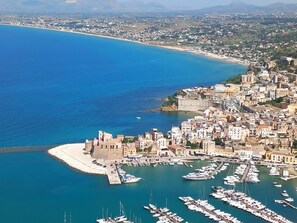 A coastal town with a marina, historic buildings, and a fortified structure.