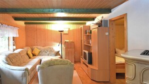 Une pièce confortable avec un canapé, une petite table et un meuble sur lequel se trouve un téléviseur.