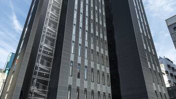 A modern high-rise building with a prominent entrance and a glass facade.