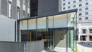 Un edificio moderno con grandes ventanales y barandilla de metal.