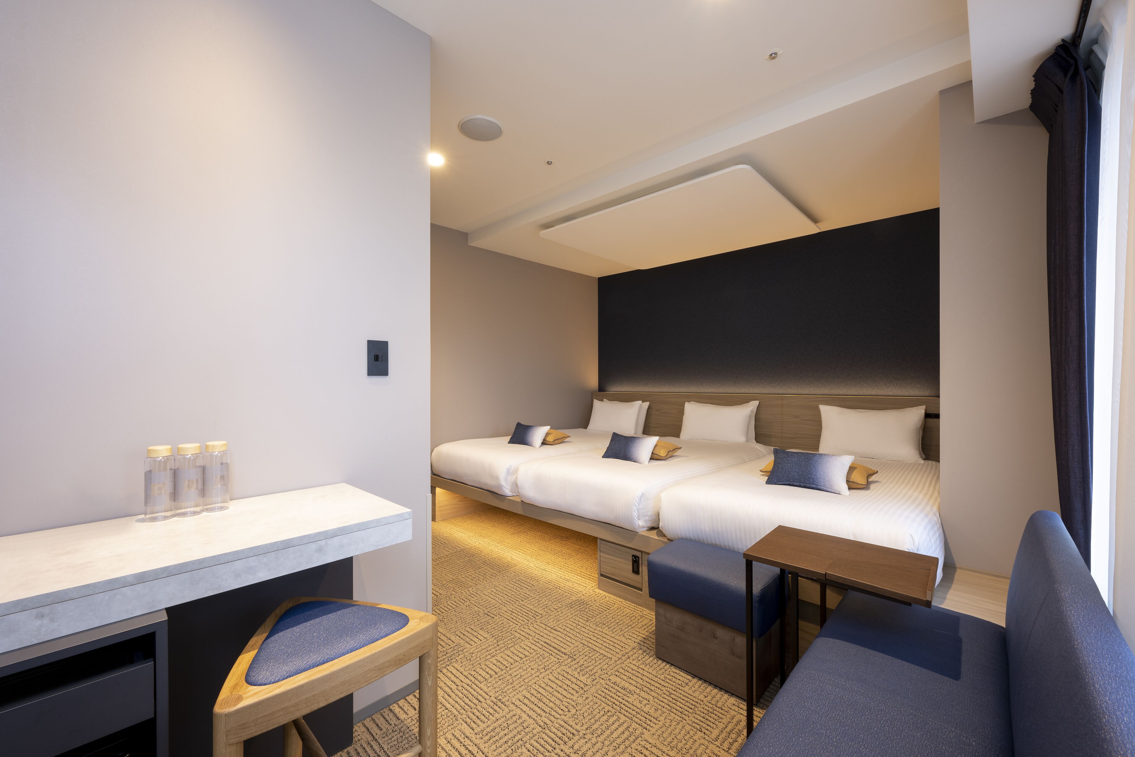 Moderni hotellihuone, jossa on suuri sänky, työpöytä ja tuoli.