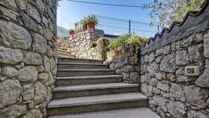 A stone staircase leading up to a building with a metal fence in the background. - Apartment 'Assenza 9' with Lake View, Wi-Fi and Air Conditioning (Brenzone sul Garda)