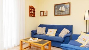 A living room with a blue sofa, a wooden coffee table, and a framed picture on the wall. - Villa Mar i Cel by Interhome (L'Ametlla de Mar)