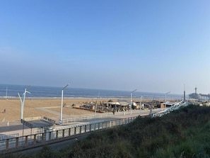 A coastal promenade with a bridge, beach, and industrial structures in the background. - Apartment in Netherlands near the Beach (Den Haag)