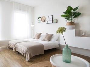 A bedroom with a bed, bedside tables, a lamp, a potted plant, and a vase on a table. - Apartment in Netherlands near the Beach (Den Haag)