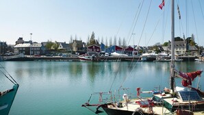 A harbor with boats, a marina, and buildings along the waterfront. - House in Saint-Quay near 7 Beaches (St. Quay-Portrieux)